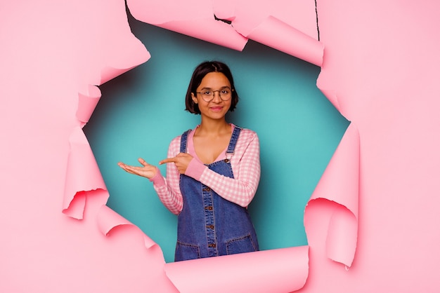 Young mixed race woman behind a broken background relaxed thinking about something looking at a copy space.