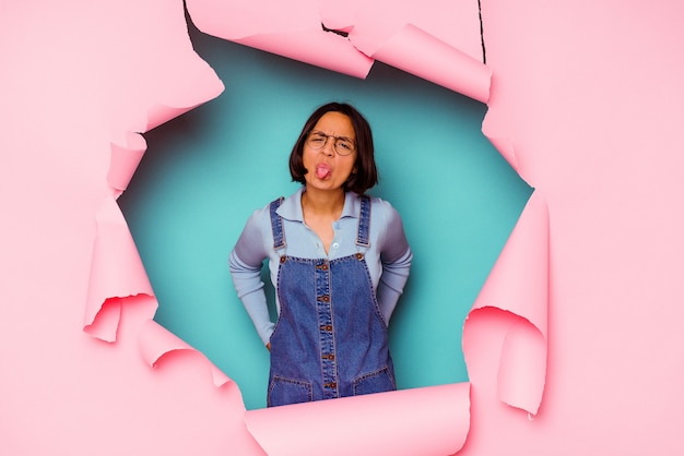 Young mixed race woman behind a broken background stretching arms, relaxed position.