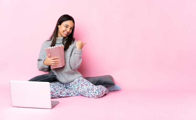 Young mixed race woman eating popcorn while watching a movie