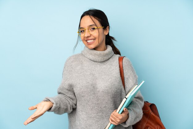 Young mixed race woman going to school on blue smiling