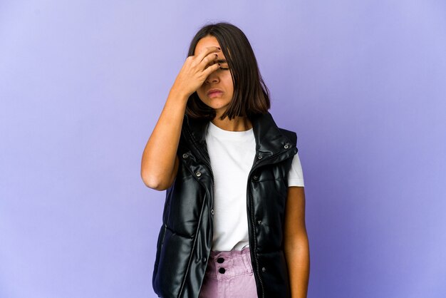 Young mixed race woman having a head ache, touching front of the face.