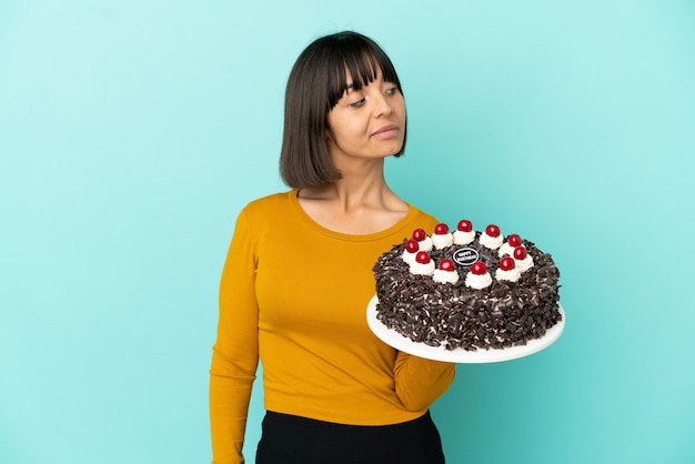 Young mixed race woman holding birthday cake . Portrait