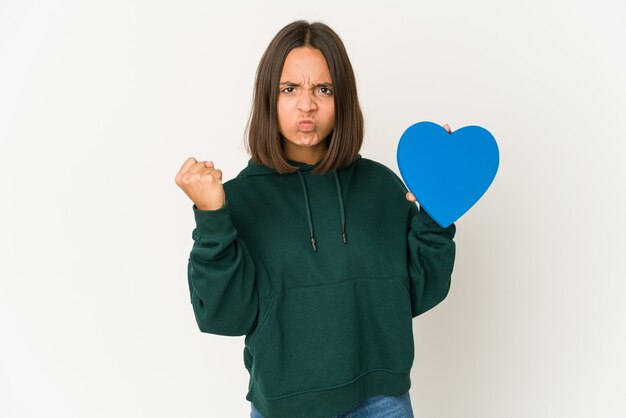 Young mixed race woman holding a blue heart isolated
