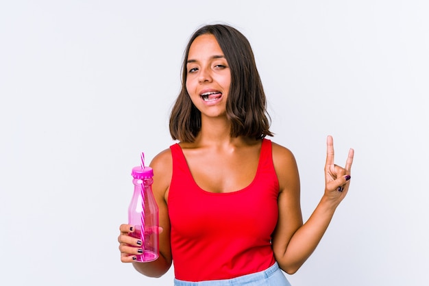 Young mixed race woman holding a milk shake isolated showing rock gesture with fingers