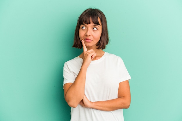 Young mixed race woman isolated on blue background celebrating a victory, passion and enthusiasm, happy expression.