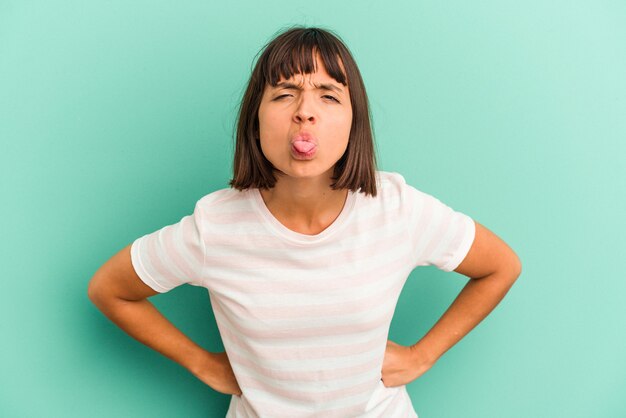 Young mixed race woman isolated on blue background doubting and shrugging shoulders in questioning gesture.