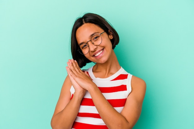 Young mixed race woman isolated on blue background feeling energetic and comfortable, rubbing hands confident.