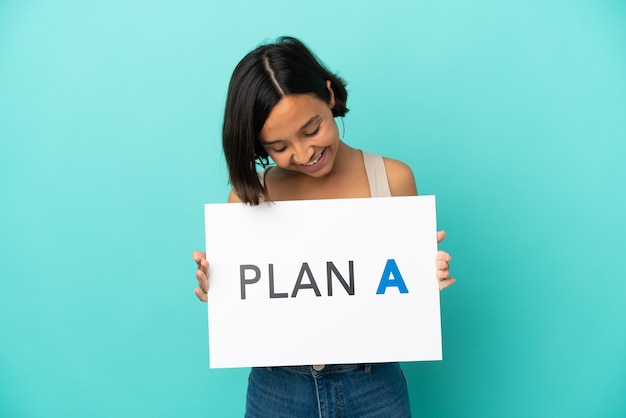 Young mixed race woman isolated on blue background holding a placard with the message PLAN A