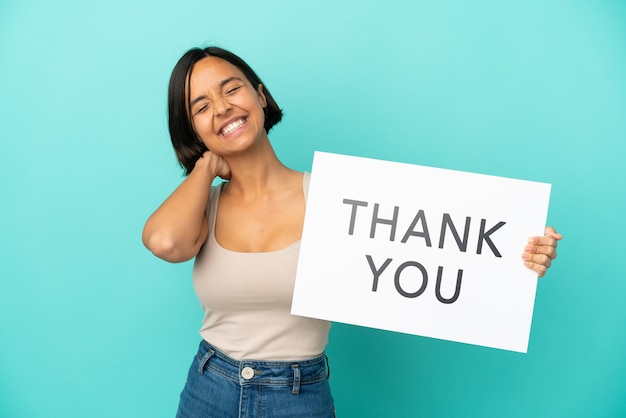 Young mixed race woman isolated on blue background holding a placard with text THANK YOU and thinking