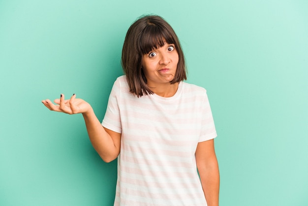 Young mixed race woman isolated on blue background shouting excited to front.