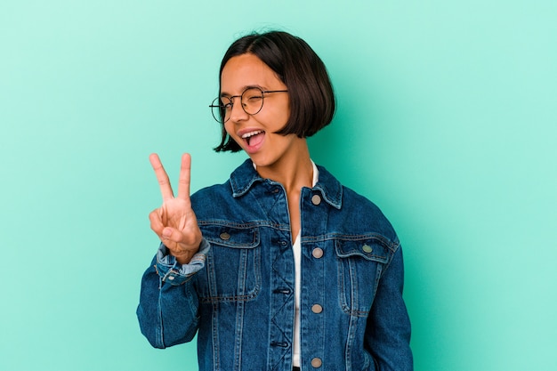 Young mixed race woman isolated on blue background showing number two with fingers.