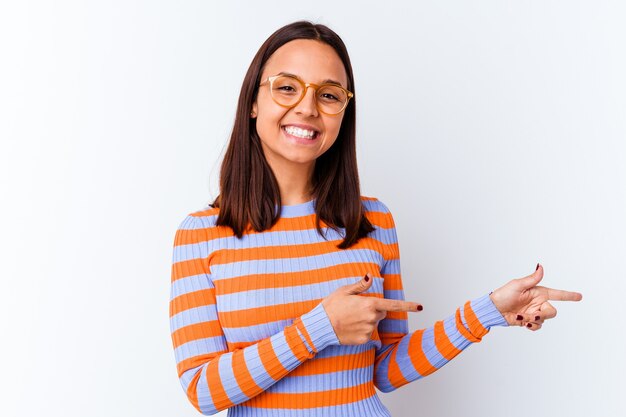 Young mixed race woman isolated excited pointing with forefingers away.