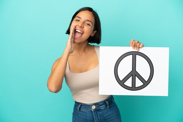 Молодая женщина смешанной расы изолирована, держит плакат с символом мира и кричит