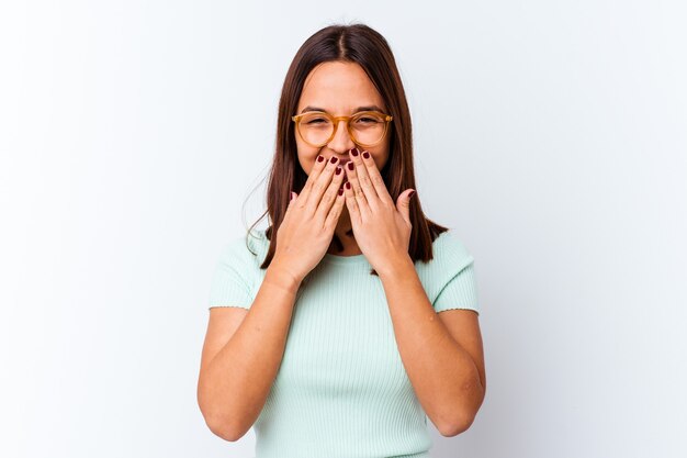 Young mixed race woman isolated laughing about something, covering mouth with hands.