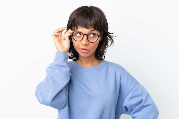 写真 眼鏡と欲求不満の表情で白い背景に分離された若い混血の女性