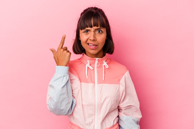 Young mixed race woman isolated on pink background showing a disappointment gesture with forefinger.