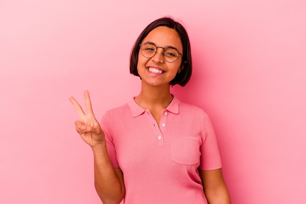 Young mixed race woman isolated on pink background showing number two with fingers.