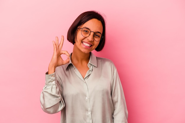 Foto giovane donna di razza mista isolata sul rosa allegro e fiducioso che mostra gesto giusto.