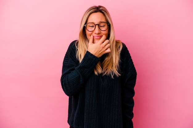 Young mixed race woman isolated on pink doubting between two options.