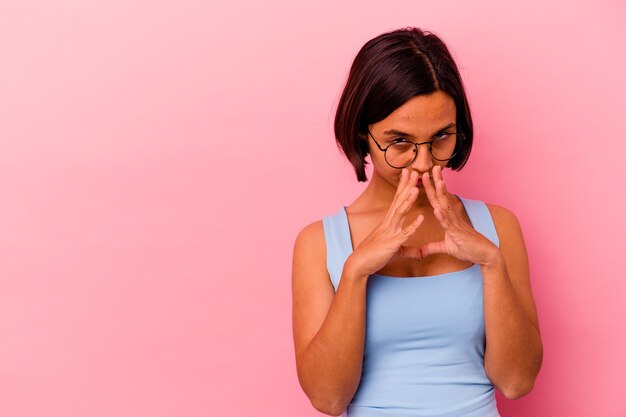 Young mixed race woman isolated on pink wall making up plan in mind, setting up an idea.