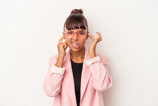 Young mixed race woman isolated on white background  covering ears with fingers, stressed and desperate by a loudly ambient.