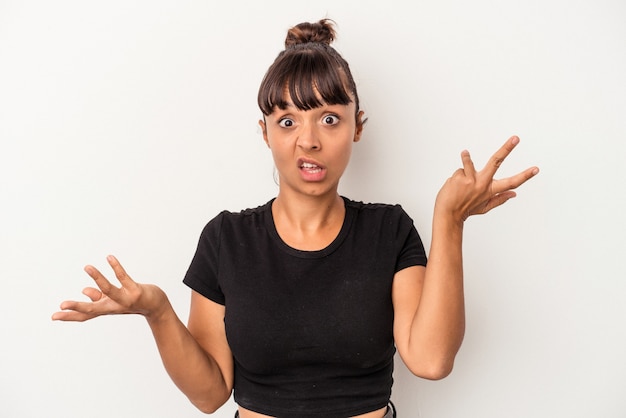 Young mixed race woman isolated on white background  doubting and shrugging shoulders in questioning gesture.