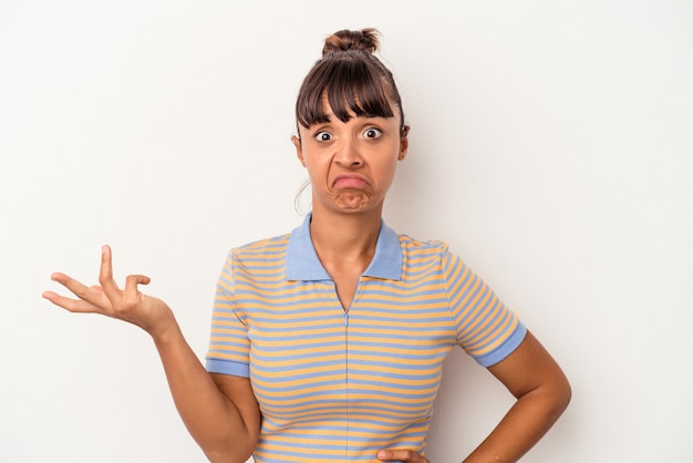 Young mixed race woman isolated on white background  doubting and shrugging shoulders in questioning gesture.