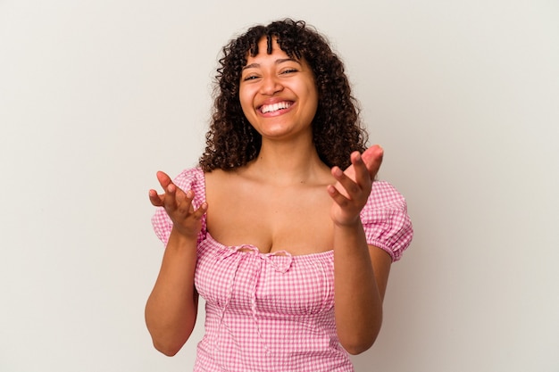 Young mixed race woman isolated on white background feels confident giving a hug to the camera.