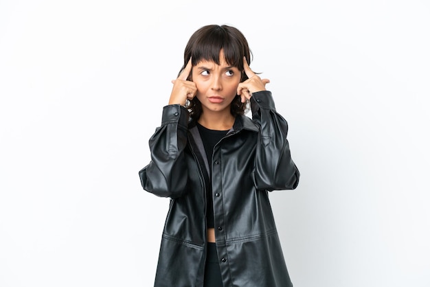 Young mixed race woman isolated on white background having doubts and thinking