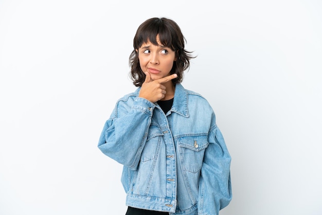 Young mixed race woman isolated on white background having doubts