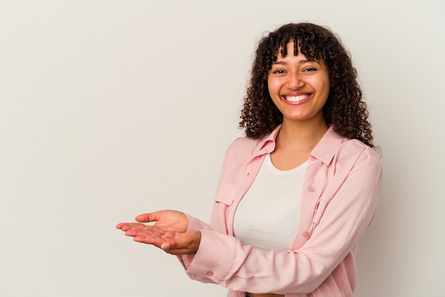 Young mixed race woman isolated on white background holding a copy space on a palm.