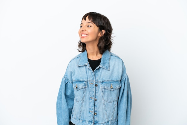 Young mixed race woman isolated on white background looking to the side and smiling