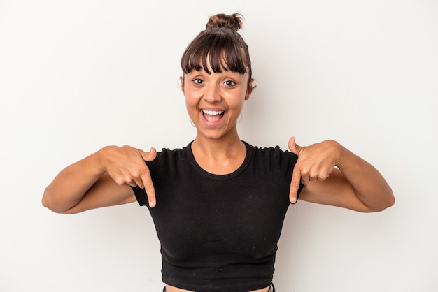 Young mixed race woman isolated on white background  points down with fingers, positive feeling.