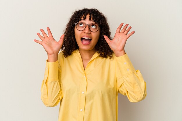 Young mixed race woman isolated on white background screaming to the sky, looking up, frustrated.