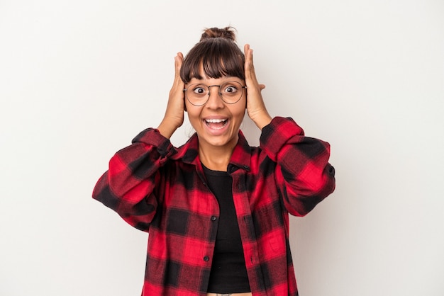 Young mixed race woman isolated on white background  screaming, very excited, passionate, satisfied with something.