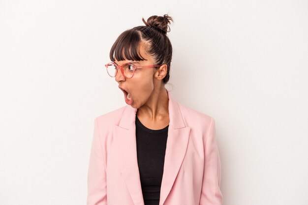 Young mixed race woman isolated on white background  shouting very angry, rage concept, frustrated.