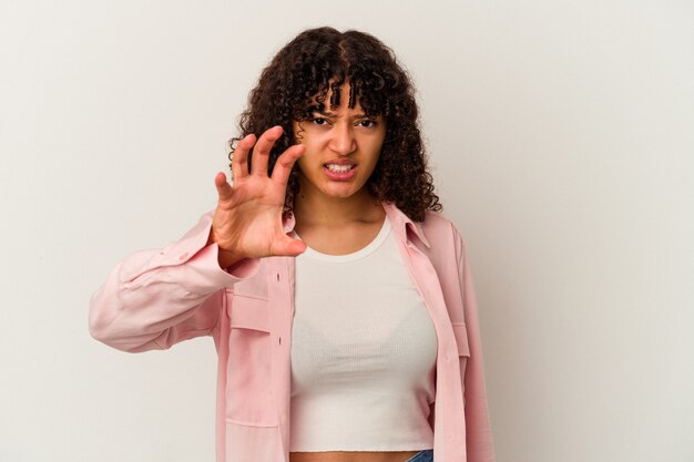 Young mixed race woman isolated on white background showing claws imitating a cat, aggressive gesture.