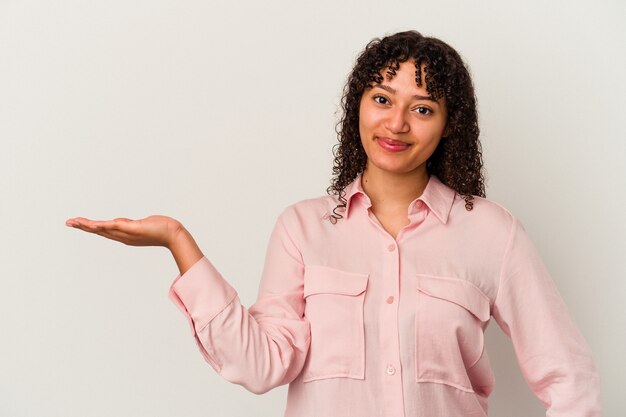 Young mixed race woman isolated on white background showing a copy space on a palm and holding another hand on waist.