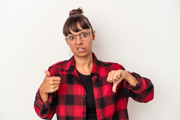 Young mixed race woman isolated on white background  showing thumbs up and thumbs down, difficult choose concept