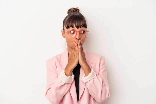 Young mixed race woman isolated on white background  thoughtful looking to a copy space covering mouth with hand.