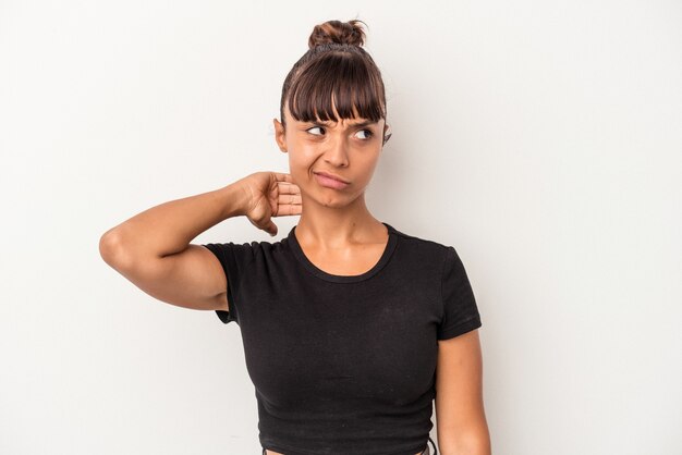 Young mixed race woman isolated on white background  touching back of head, thinking and making a choice.