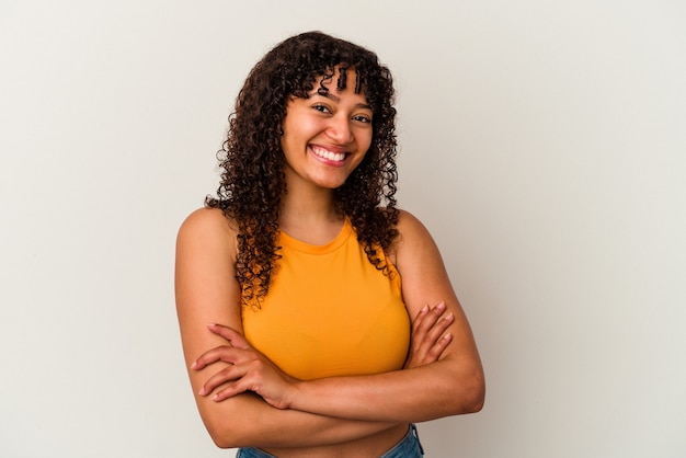 Young mixed race woman isolated on white background who feels confident, crossing arms with determination.