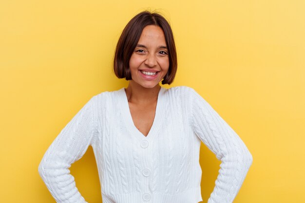 Photo young mixed race woman isolated on yellow background confident keeping hands on hips.