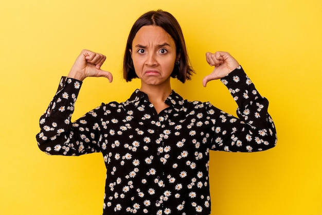 Young mixed race woman isolated on yellow background feels proud and self confident, example to follow.