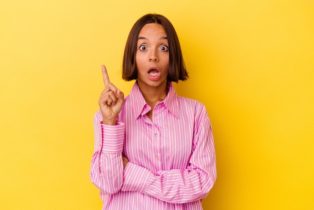 Young mixed race woman isolated on yellow background having some great idea, concept of creativity.