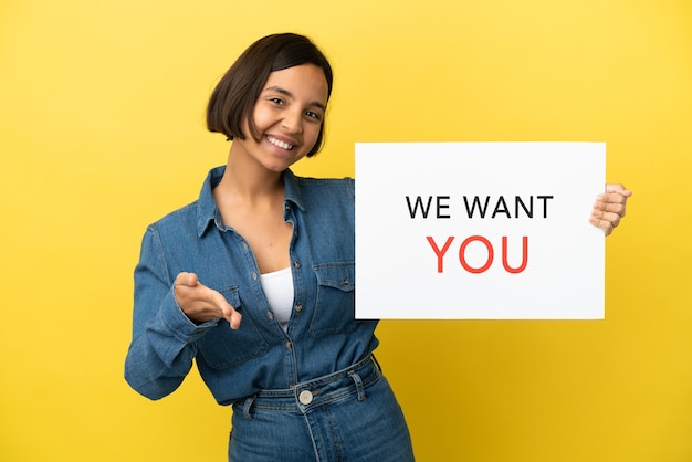 Young mixed race woman isolated on yellow background holding We Want You board making a deal