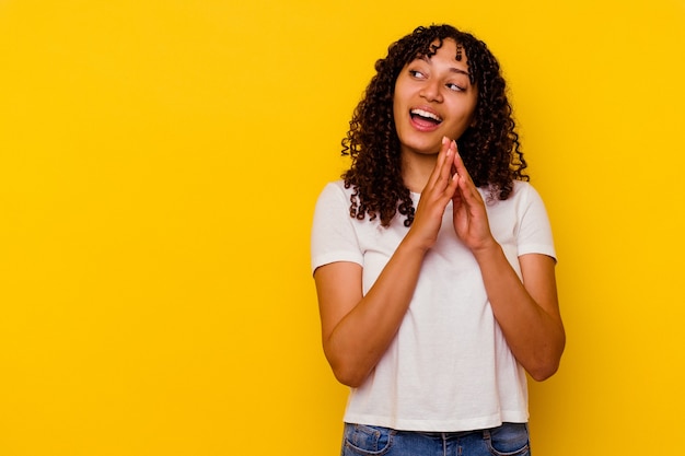 Young mixed race woman isolated on yellow background making up plan in mind, setting up an idea