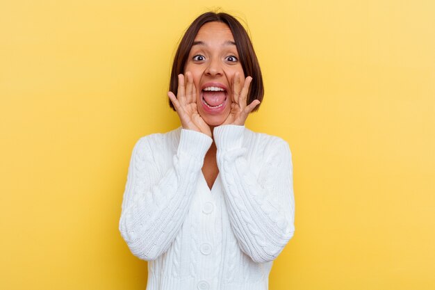 Young mixed race woman isolated on yellow background shouting excited to front.