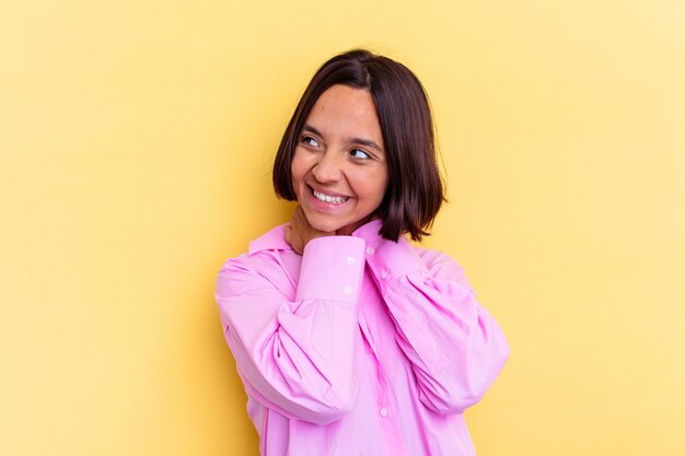 Young mixed race woman isolated on yellow background stretching arms, relaxed position.