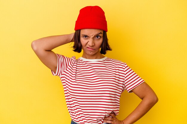 Young mixed race woman isolated on yellow background suffering neck pain due to sedentary lifestyle.